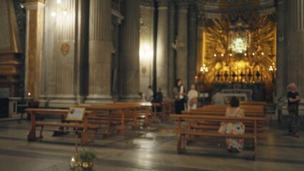 Blurred church interior with soft shallow bokeh and defocused altar, pews and columns in warm...