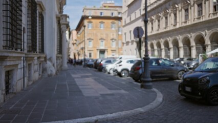 Defocused city street with parked cars, cobblestone curb and ornate building facades in soft bokeh street; background.
