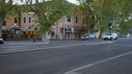 Blurred street scene with soft bokeh and defocused buildings and trees; background copyspace backplate calm.