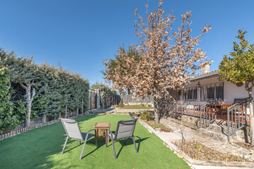 Terrace with pet-friendly artificial grass, a wooden pergola with vines, and a dining set for six