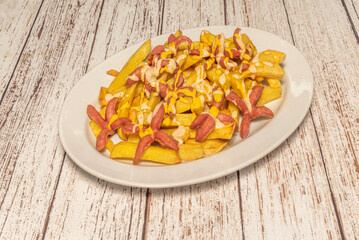 Fried sausages with julienned onions and tomato slices, presented on creamy mashed potatoes garnished with chopped parsley