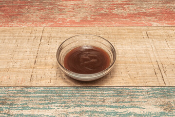 Small glazed  cups with whiskey barbecue sauce, decorated with sprinkled toasted sesame seeds