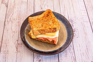 Gourmet Club Sandwich: Smoked turkey, Serrano ham, Brie cheese, and cranberry jam on toasted rustic bread