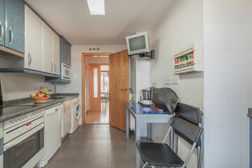 Contemporary kitchen with a hexagonal tile wall, modular cabinets, and  appliances