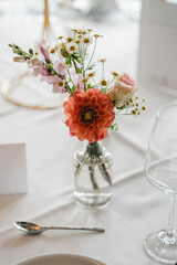 Elegante Tischdekoration mit Blumenarrangements in Pfirsich- und Rosatönen, festlich gedeckter Tisch im modernen Saal