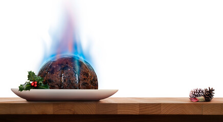 A level view of a traditional Christmas pudding on a square plate with holly and blue flames of...