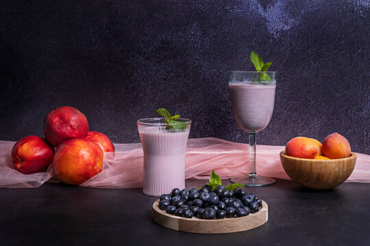 Minimalist arrangement with blueberries and a blueberry and lemon smoothie on a Danish beech wood board