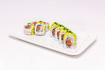 Tuna and cucumber uramaki with pickled ginger, on a gold-rimmed porcelain plate
