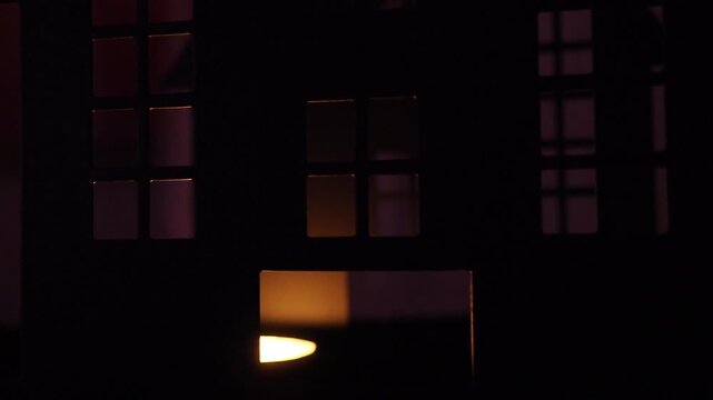 Dark shadows dance in a spooky castle as candlelight flickers through the windows. The eerie atmosphere creates a sense of fear and suspense on Halloween night