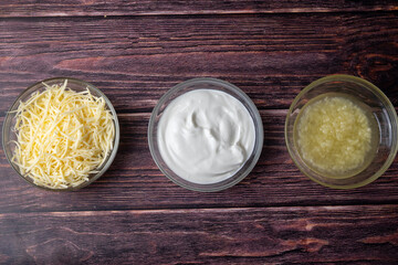 Three Glass Bowls with Toppings on Wooden Table