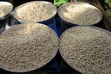 Freshly peeled white beans piled in round metal trays under natural light, full-frame pattern; for food design, retail signage, recipe content, education.