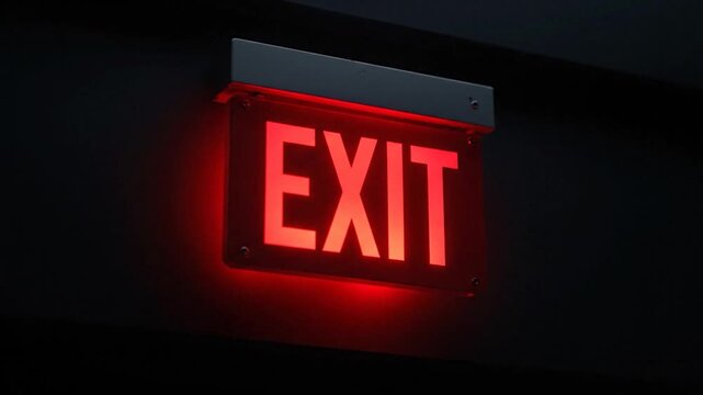 Illuminated red EXIT sign glowing against a dark background, providing guidance in a dark setting