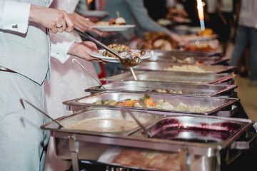 Professionelles Catering-Buffet mit Warmhaltebehältern und reichhaltiger Auswahl an Speisen auf einem festlichen Bankett