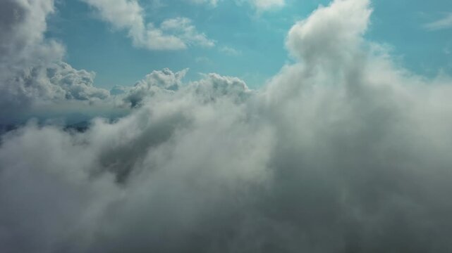 Aerial high view of clouds and blue sky, flying in clouds, 4k