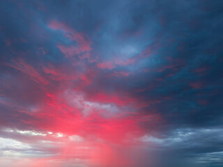 Dramatic sky with storm clouds illuminated by red sunset or sunrise. Vivid colorful cloudscape for nature banner or weather background. Bright sunset or sunrise light.
