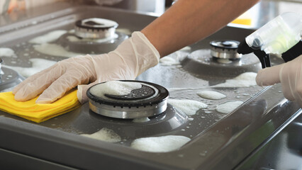 Woman of cleaning cooker indoors at home