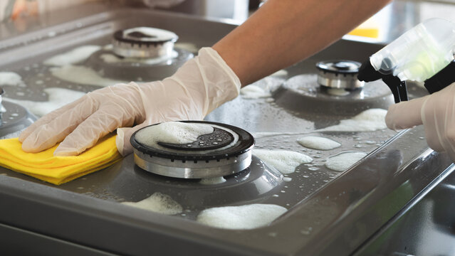 Woman of cleaning cooker indoors at home
