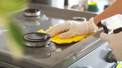 Woman of cleaning cooker indoors at home