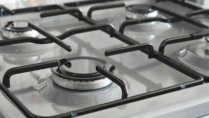 Close-up of a blue fire from a kitchen stove. 4 gas burners with a burning flame. economy concept.