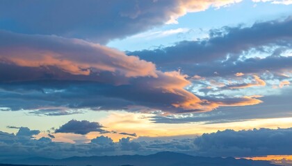 Scenic skyscape features billowing clouds with hues of pink, orange, and blue at sunset or sunrise