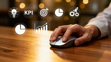 Hand using computer mouse with floating business and analytics icons over wooden desk