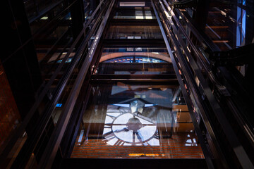 Obraz premium View of clock tower interior with intricate metal and glass structures reflecting light. architectural design creates dramatic Clock tower
