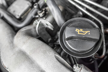 An engine oil cap with the oil symbol on a car engine