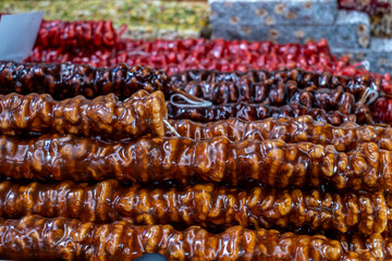 Traditional Georgian dessert featuring elongated strands of nuts coated in a glossy syrup, showcasing vibrant colors and textures, perfect for culinary exploration and cultural appreciation