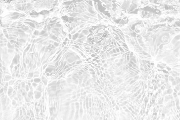 White water with ripples on the surface. Defocus blurred transparent white colored clear calm water surface texture with splashes and bubbles. Water waves with shining pattern texture background.
