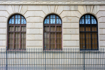 アーチ窓と鉄柵が印象的なクラシックな石造建築の外観