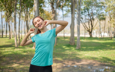 Obraz premium Cheerful woman doing warm up exercises outdoors. Healthy lifestyle, fitness, and wellbeing concept