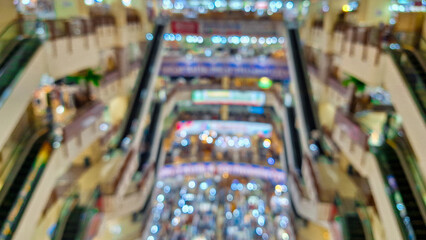 defocused interior ambiance of a shopping mall, popular destination to looking for clothing, accessories, and other household items at affordable prices. 