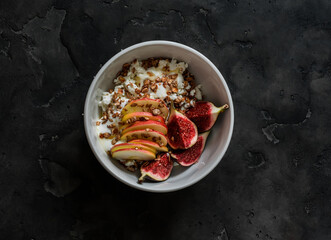 Delicious healthy breakfast - cottage cheese with Greek yogurt, granola, apple, figs and honey on a...