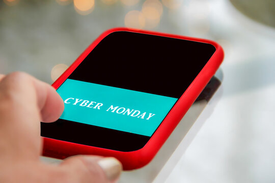 Low angle closeup view of person shopping online exclusive deals during cyber Monday event using mobile device on this ecommerce day offered by retailers following Thanksgiving weekend.