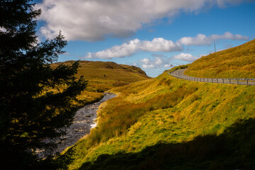 Obraz premium Winding Road and Flowing Stream in the Mountains of Snowdonia, Wales
