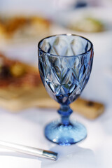 Elegant blue glass on a dining table with food nearby