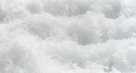 White water with ripples on the surface. Defocus blurred transparent white colored clear calm water surface texture with splashes and bubbles. Water waves with shining pattern texture background.