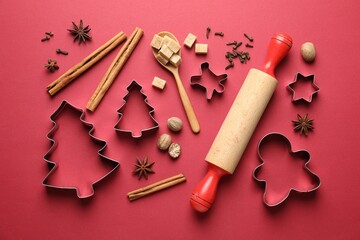 Cookie cutters and ingredients on red background, flat lay. Christmas season