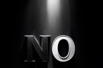 The word no in silver letters is illuminated by a bright spotlight
