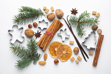Christmas composition with fir tree branches, cookie cutters and spices on white background, flat lay