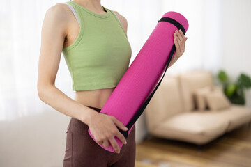 Woman in Activewear Holding Pink Yoga Mat Indoors