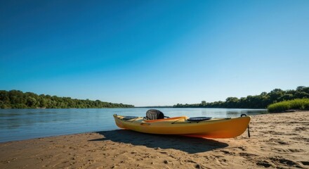 Yellow kayak on sandy shore, river stretching to treeline under clear blue sky