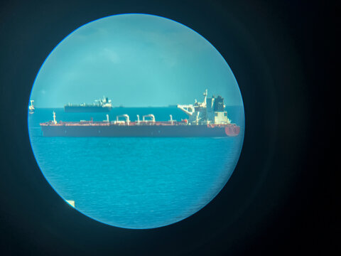A tanker vessel with no visible identification marks, possibly a symbol of the so-called "shadow" or "sanction fleet", photographed through an optical device