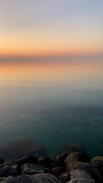 Beautiful sunset at sea. Large stones on the seashore at sunset.