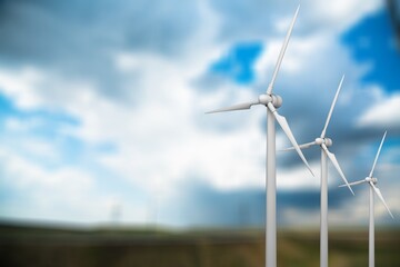 A row of tall white wind turbines at blue sky