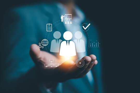 Businessman holding digital HR icons representing team management, recruitment, leadership, and business performance analytics. Concept of digital human resource and workforce innovation.