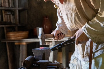 Schmied schmiedet glühendes Metall mit Hammer
