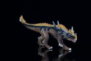 Plastic dragon figurine on a black background