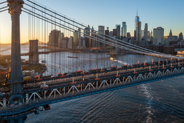Aerial view of the Manhattan Bridge stretching across the East River, with the One World Trade Center piercing the skyline in the golden light of dusk, Manhattan, New York, United States.
