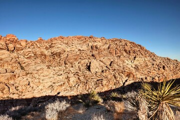 Vibrant Red Sandstone Peaks Rise Majestically Against Azure Skies in Red Rock Canyon's Ancient Desert Embrace, Nevada